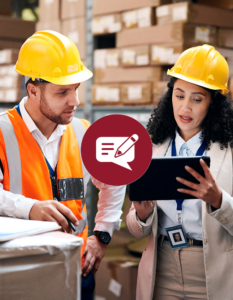 A female supply chain manager and her employee viewing a tablet in a storage facility wearing hats.